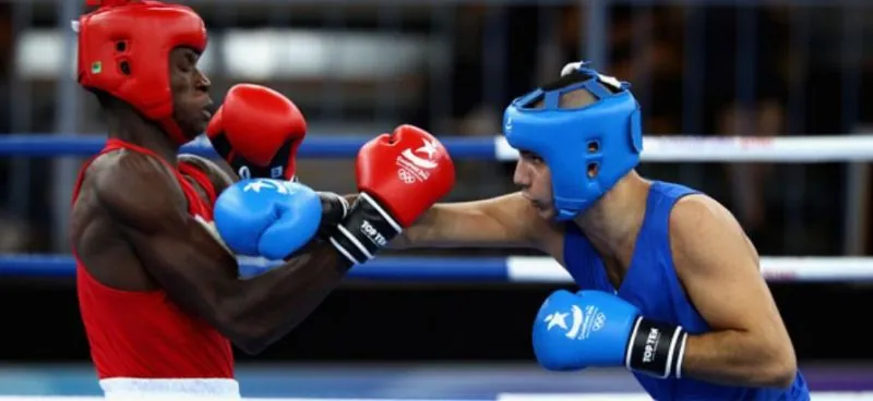 A Nigerian boxer in red trading punches in an amateur bout