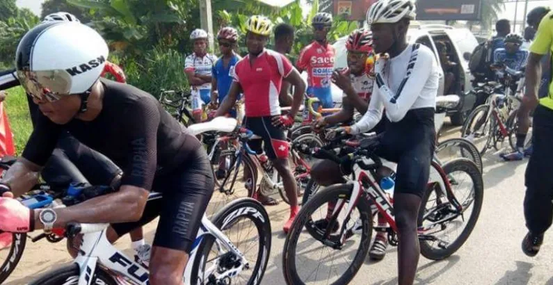 Nigerian road cyclists with helmets and racing bikes waiting at the start of a race