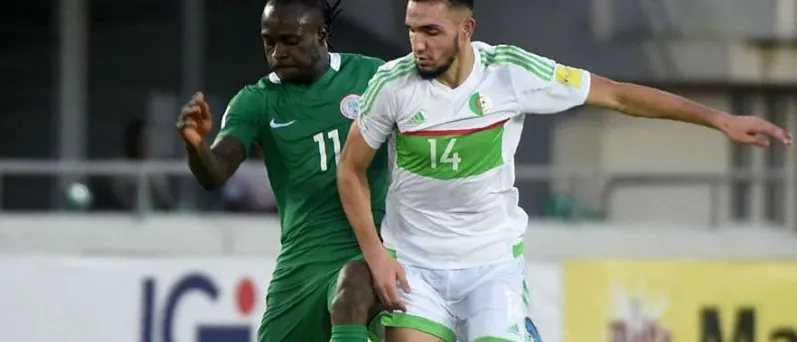 A Super Eagles forward challenging an Algeria defender