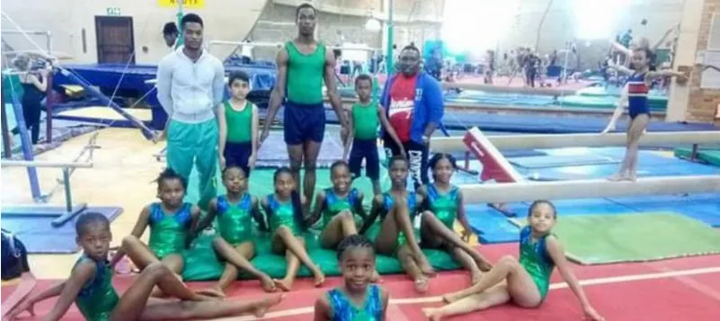 Nigerian junior gymnasts with their coaches in a gym