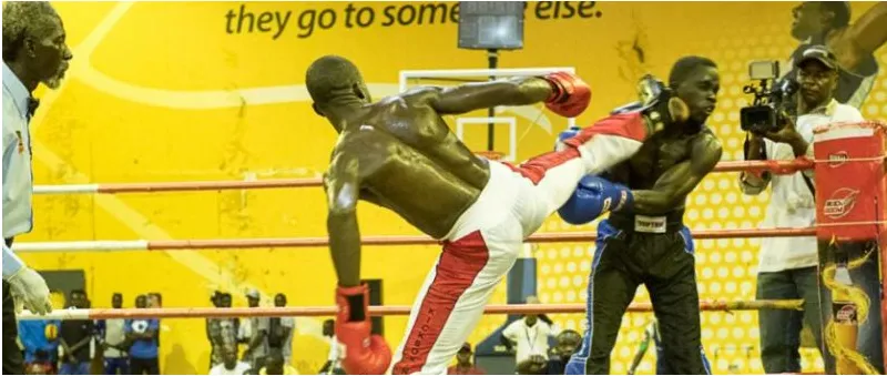 A Nigerian kickboxer landing a kick in a ring in Nigeria