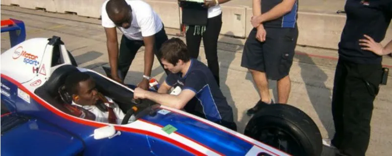 A Nigerian driver being strapped into a single-seater racing car