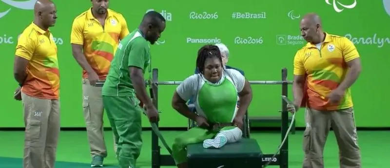 A Nigerian para powerlifter in green prepares to lift on the bench at the Rio 2016 Paralympics