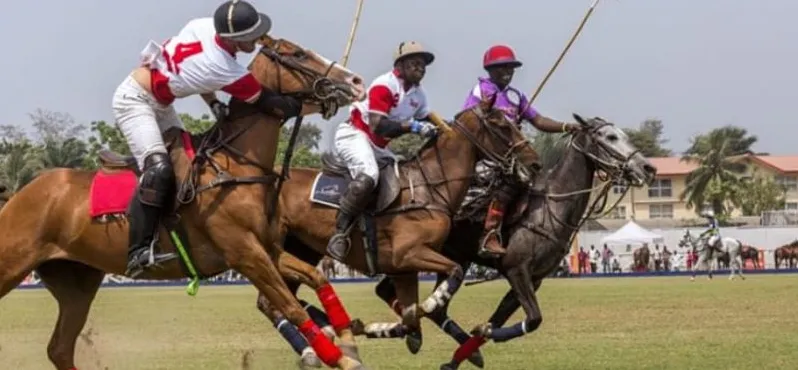 Polo players galloping across the field at a Nigerian tournament