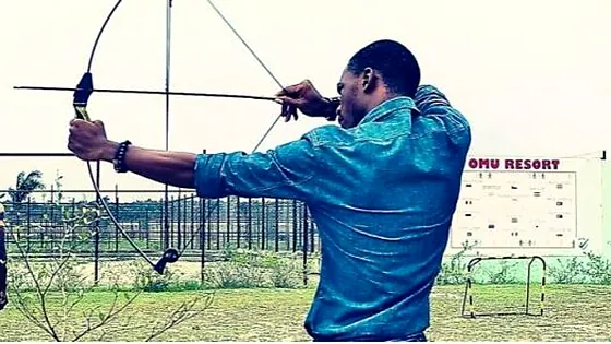 Nigerian archer drawing a bow on an outdoor range