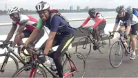 Road cyclists racing along a Nigerian waterfront