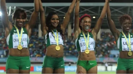 Nigerian relay medallists celebrating with arms raised