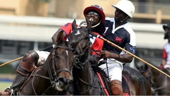Polo players on horseback chasing the ball